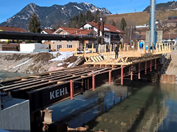 Zur Herstellung des Brückenüberbaus wurde ein Tragsystem mit Stahlträgern errichtet. Darauf wird gerade die Holzschalung zum Bau der Spannbetonbrücke ausgerichtet.
